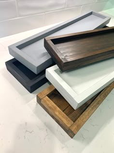 three wooden trays are stacked on top of each other in different colors and sizes