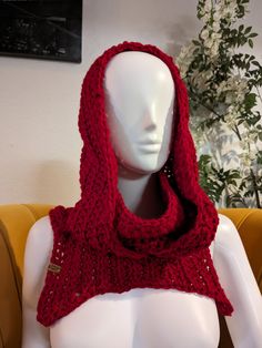 a white mannequin wearing a red knitted scarf