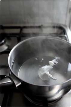 a frying pan filled with boiling liquid on top of a stove