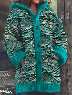 a woman standing next to a wooden fence wearing a green jacket