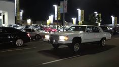 a white truck driving down a street at night