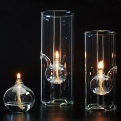 two clear glass vases with candles in them