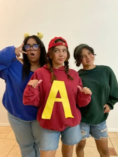 three girls dressed in costumes posing for the camera