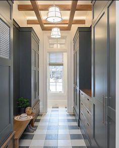 a long hallway with black and white checkered flooring next to a large window