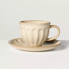 a white cup and saucer sitting on top of each other