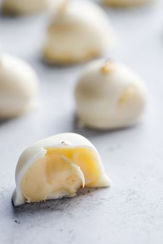 an egg is broken in half on a cookie sheet with other cookies behind it, all covered in white icing