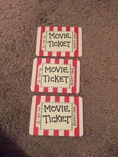 three movie tickets sitting on the floor next to each other with words written on them