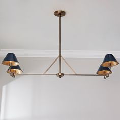 a chandelier with three blue lamps hanging from it's sides in a room