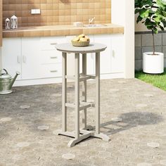 a small table with some fruit on it in the middle of a kitchen flooring area