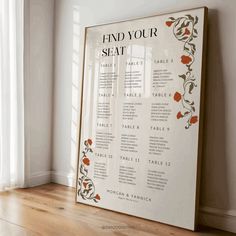 a framed seating chart on the wall next to a window