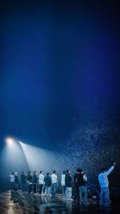 a group of people standing on top of a stage next to each other under a spotlight