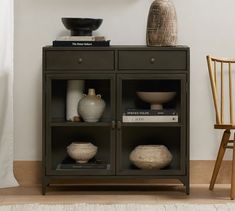 a shelf with vases on top of it next to a chair