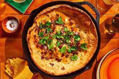 a pizza sitting in a pan on top of a table next to glasses and napkins