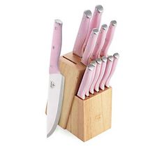 a pink knife holder with many knives in it and a wooden block on the side