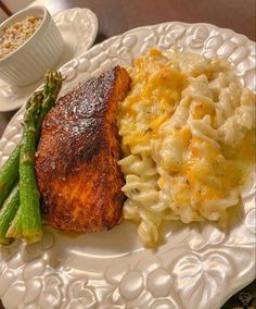 a white plate topped with macaroni and asparagus