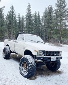 a white pick up truck parked in the snow