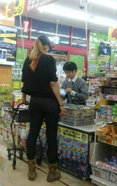 two people standing at the counter in a store