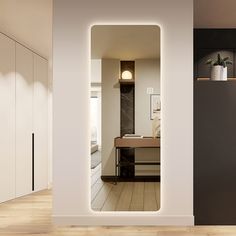 an open door leading to a bedroom with white walls and wood flooring on the side