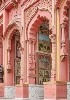 an ornate pink building with gold trim and arches