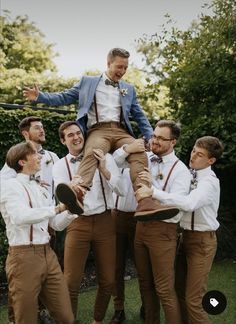 a group of men standing around each other on top of a man's shoulders