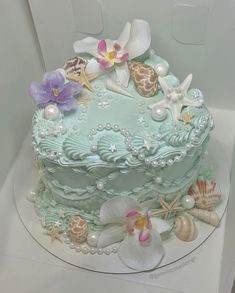 there is a cake decorated with seashells and flowers