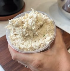 a person holding up a plastic container filled with food