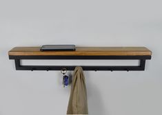 a cell phone is hanging on a shelf above a coat rack with keys and an umbrella