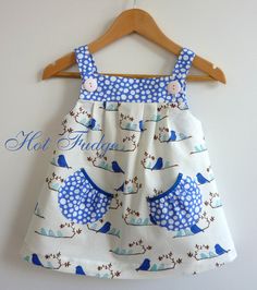 a white and blue dress hanging on a wooden hanger