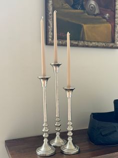 two silver candles sitting on top of a wooden table