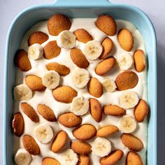 a blue casserole dish filled with banana slices and cream