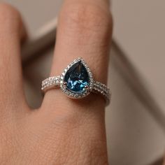 Blue topaz ring pear engagement ring sterling silver pear | Etsy Silver Pear-shaped Ring With Halo Setting, Elegant Topaz Teardrop Rings, Silver Halo Teardrop Rings, Silver Teardrop Halo Rings, Formal Teardrop Topaz Rings, Elegant Sterling Silver Pear-shaped Topaz Ring, Teardrop Topaz Ring With Accent Stones For Anniversary, Elegant Pear-shaped Topaz Ring In Sterling Silver, Anniversary Blue Topaz Teardrop Ring