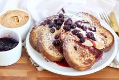 french toast topped with blueberries and powdered sugar next to a cup of coffee