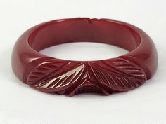 Red Bakelite Carved Cuff Bracelet This is a beautiful, 3/4" wide bakelite cuff bracelet with a leaf and flower design. It is a deep red color bakelite. The bracelet is unusual in that one side is rounded and the other side is flat, so it can be paired well stacked against other bracelets when worn on the wrist. This bracelet is in fair condition although it does have one chip that is mostly visible from the inside of the bracelet. Please view the last three photos for closeups. We will be listing several bakelite bracelet this week, so be sure to check out our ebay store. Feel free to contact us with any questions or photo requests. ***International Buyers – Please Note: Import duties, taxes, and charges are not included in the item price or shipping cost. These charges are the buyer's res Bakelite Bracelets, Leaf Flower, Deep Red Color, Leaf Flowers, Deep Red, Flower Design, Bangle Bracelet, Cuff Bracelet, Flower Designs