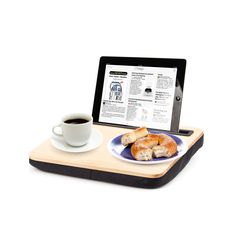 a tablet is sitting on a tray with a plate of food and cup of coffee