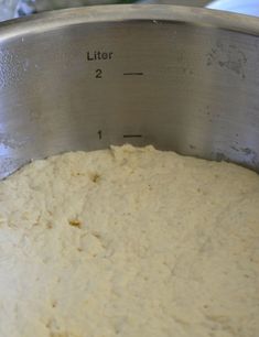 a metal bowl filled with batter on top of a counter