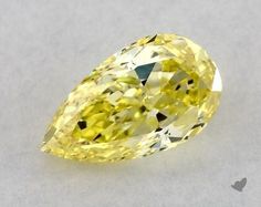 a fancy yellow diamond on a white surface