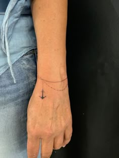 a person with a small anchor tattoo on their wrist