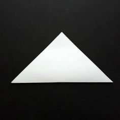 an origami triangle on a black background with space for the letter e to be cut out