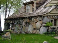 a house made out of rocks sitting in the grass