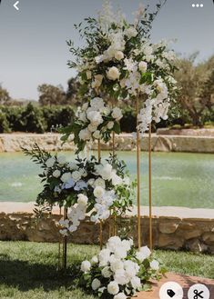 an outdoor ceremony setup with white flowers and greenery in the foreground, near a pool