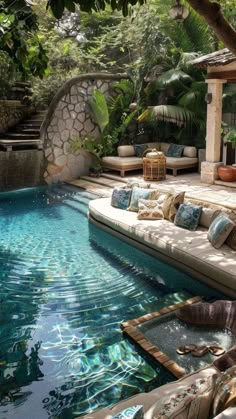 an outdoor living area with couches and a pool in the middle, surrounded by greenery