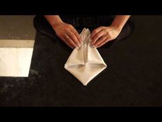 a woman is sitting on the floor with her hand on an empty napkin that has been folded