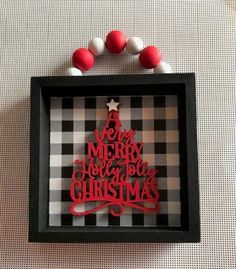 a black and white checkered wall with a red christmas tree cut out in it