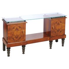 a glass top sideboard with two drawers on legs and one drawer open to show the contents