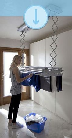 a woman is hanging clothes on a rail