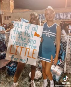 two girls holding up a sign that says out of all the fish in the sea you're the little for me