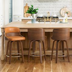 a kitchen island with three stools in front of it