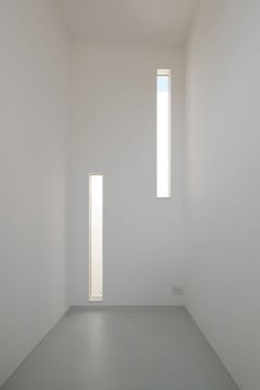 an empty white room with two windows and no one in the room on the floor