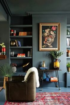 a living room filled with furniture and bookshelves next to a painting on the wall