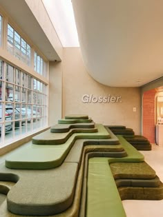 a long row of green benches in front of a large window with the word glosster on it